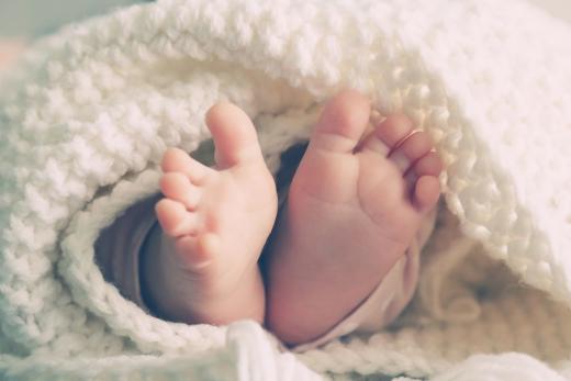 Pezinhos de um bebê recém nascido debaixo de um cobertor